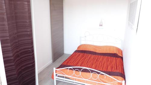 迪纳尔Appart Bord De Mer Dinard的一间卧室配有一张带橙色毯子的床