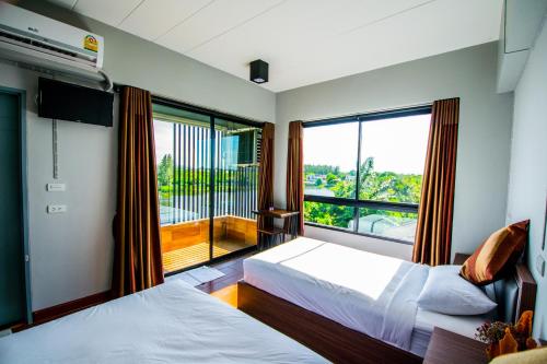 北榄府纳塞利湖景公寓的一间卧室设有两张床和大窗户