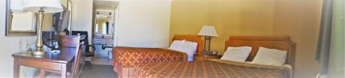 莫哈韦莫哈韦行政酒店的一间卧室配有两张床、一张桌子和一盏灯。