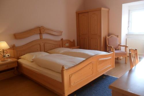 奥特贝格巴德司徒贝酒店的一间卧室配有一张大型木床和椅子