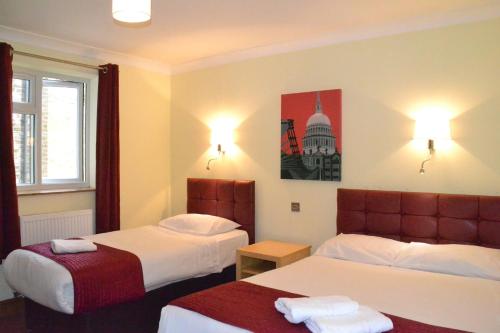 伦敦65酒店的酒店客房设有两张床和窗户。
