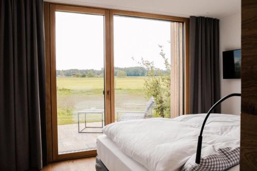 BalzhausenHotel Lenderstuben的一间卧室设有一张床和一个滑动玻璃门
