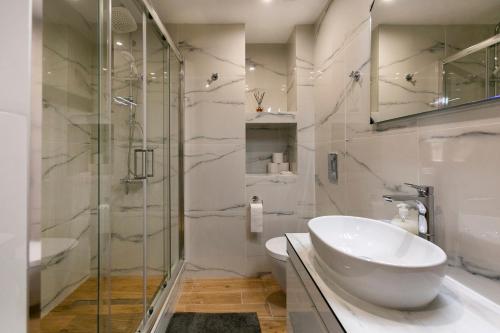 雅典Raise cosy apartment的白色的浴室设有水槽和淋浴。