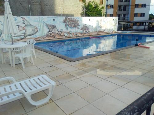 阿拉卡茹Condominio Port. da cidade Aracaju的一个带桌子和桌椅的游泳池