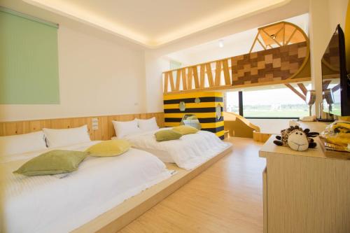 冬山乡梅花森林亲子民宿的一间卧室设有两张床和一张高架床。
