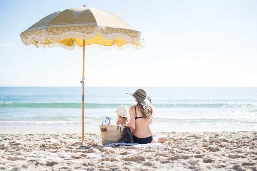 努萨角停吉拉纳努沙酒店的坐在海滩上,在伞下的一个女人