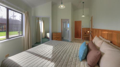 彭特派因海风别墅公寓的一间卧室设有一张大床和一个窗户。