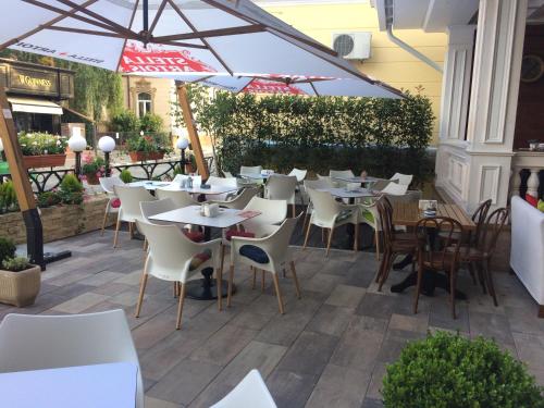 拉姆尼库沃尔恰卡斯特利酒店的一间带桌椅和遮阳伞的餐厅
