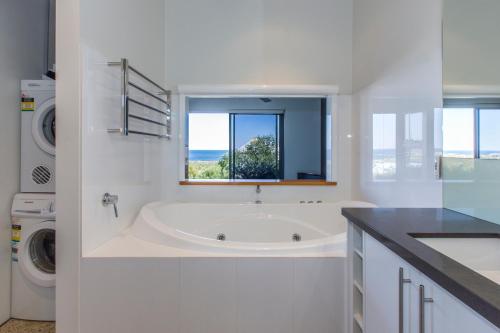 玛格丽特河Aquatic Visions Studio Apartments的白色的浴室设有浴缸和窗户。