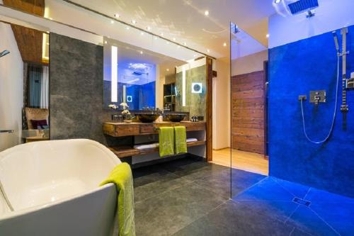上陶恩辛德瑞拉运动酒店的大型浴室设有浴缸和淋浴。