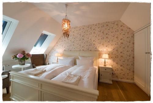 朗克维茨Bauernkate Seerose的卧室配有一张白色大床和花卉壁纸