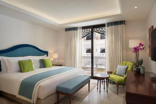 多哈Al Najada Doha Hotel Apartments by Oaks的卧室配有一张床和一张桌子及椅子