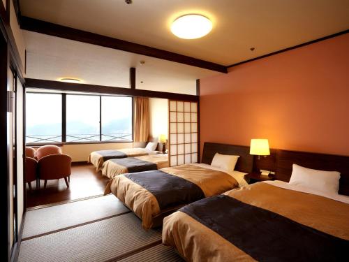 长崎长崎日升馆的酒店客房设有三张床和窗户。