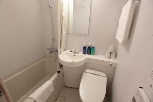 高松高松世纪酒店的白色的浴室设有卫生间和水槽。