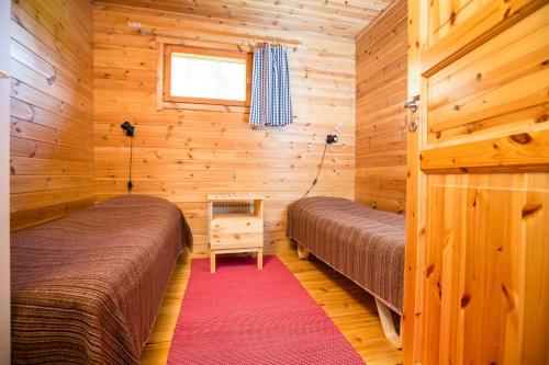 蓬卡哈尤纳兰拉蒂度假酒店的小木屋内一间卧室,配有两张床