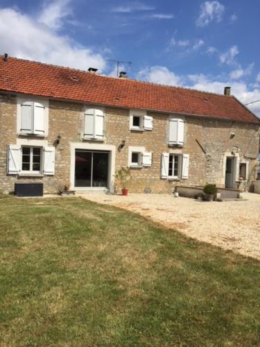 PréhyLa maison de Lucien, gîte au cœur du vignoble Chablisien的一座大型砖房,前面有一座院子