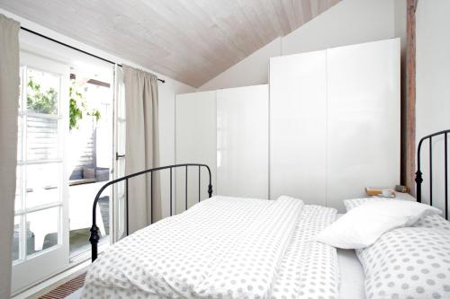 米库洛夫Ubytování v Renesančním domě的一间白色卧室,配有两张床和窗户