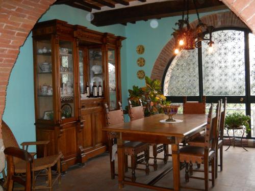丘西拉巴迪奥拉农家乐的一间带桌子和瓷器橱柜的用餐室