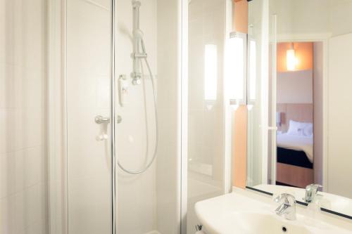 格勒诺布尔格勒诺布尔宜必思酒店的带淋浴和盥洗盆的白色浴室