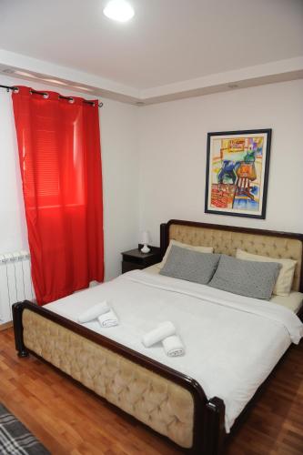 尼克希奇Apartments Erakovic的一间卧室配有一张带红色窗帘的大床