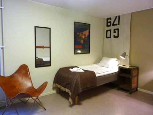 Lyrestad诺科瓦恩酒店的一间卧室配有一张床、一把椅子和镜子