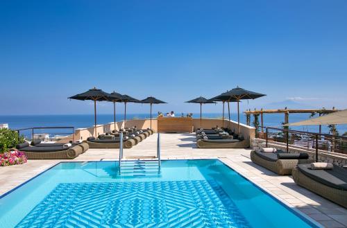 卡普里卡普里滨海别墅酒店的一个带躺椅和遮阳伞的游泳池