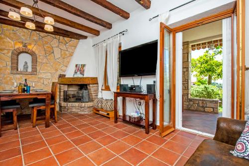 罗维尼Monte Holiday Home with Jacuzzi的客厅设有石制壁炉和电视。
