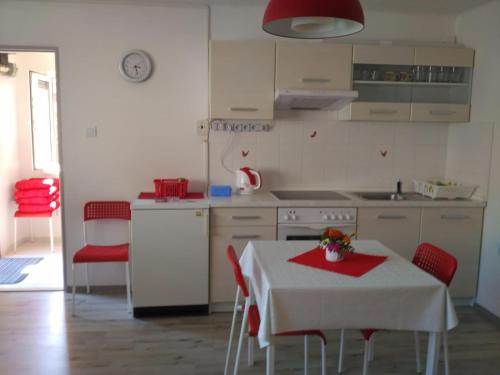斯塔勒斯普拉维Apartmán v Zátiší的厨房里配有一张桌子,上面有红色的餐巾