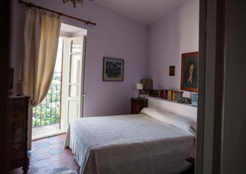 CugnoliDimora Il Palazzetto的一间卧室设有一张床和一个大窗户