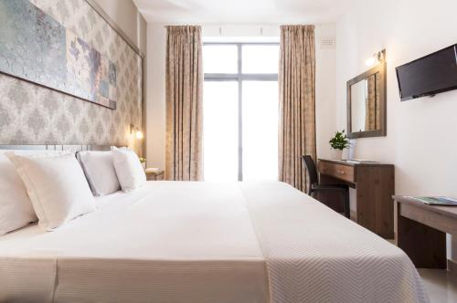 圣朱利安斯亚历山大酒店的酒店客房设有一张白色大床和一张书桌