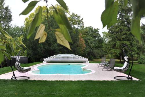 Penne-dʼAgenaisLe Manoir De Bonal的庭院里一个带椅子的游泳池