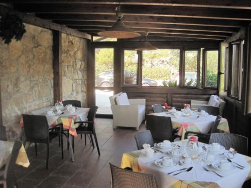 锡拉库扎B&B Villa Giusy的餐厅设有白色的桌椅和窗户。