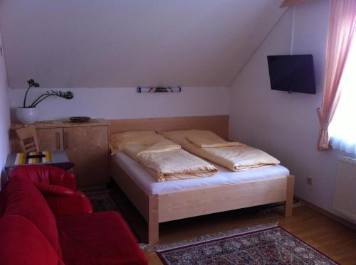 巴特斯哈尔巴赫Gästehaus AIGMÜLLER的一间小卧室,配有一张床和一张红色的沙发