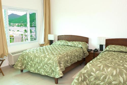 辛普森湾辛普森湾套房酒店的一间卧室设有两张床和窗户。
