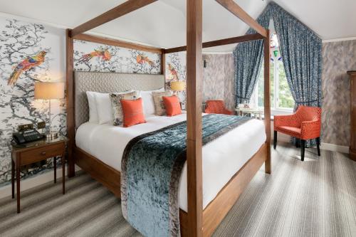温德米尔Cedar Manor的一间卧室配有带橙色枕头的天蓬床