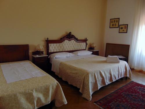 陶尔米纳萨拉别墅酒店的一间卧室配有两张床和两张带毛巾的桌子。