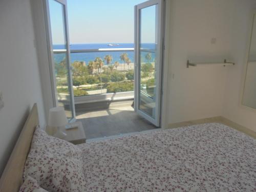 利马索尔Kermia Court - Beach-front, modern 2 bedroom -sleeps 6的一间卧室配有一张床,享有海景