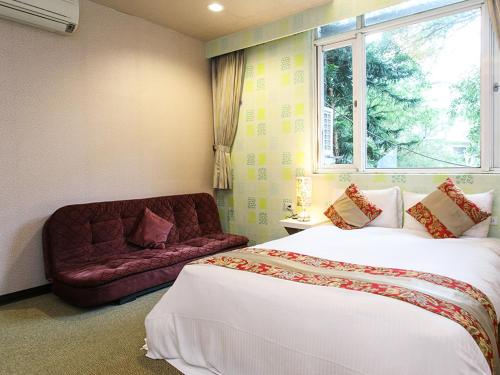 乌来乌来驿站的一间卧室配有一张床、一张沙发和一个窗口