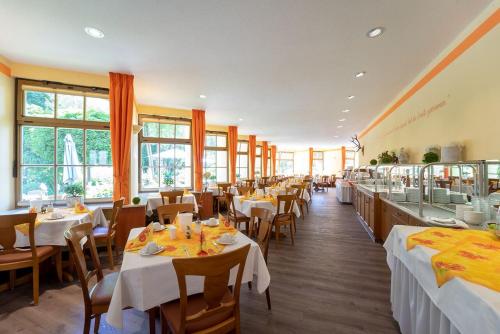 苏尔希尔施高登纳酒店的餐厅设有白色的桌椅和窗户。