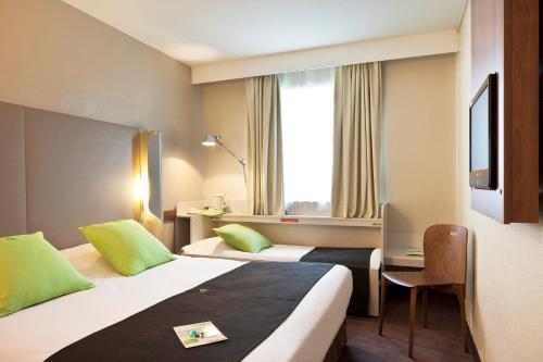 尚布雷莱图尔南钟楼旅行时光酒店客房内的一张或多张床位