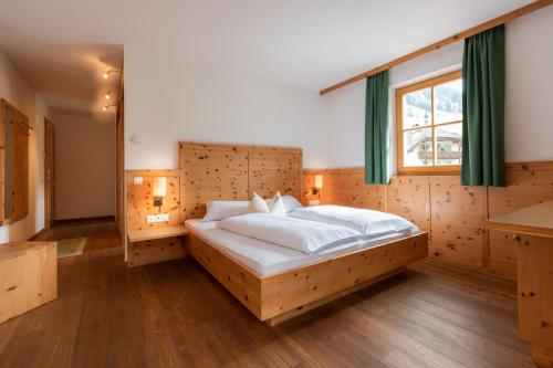 里约比安科Hotel Alpenfrieden的一间卧室设有一张大床和一个窗户。