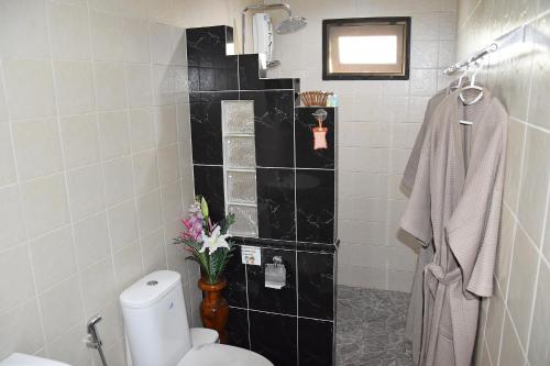 清莱清莱家庭旅馆的浴室设有卫生间和黑色瓷砖墙。