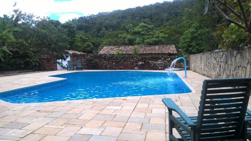 戈亚斯Pousada do Ipe的一个带两把椅子的游泳池和一个喷泉