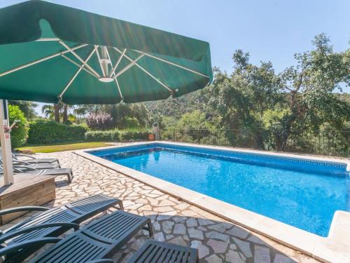 卡隆赫Belvilla by OYO Villa Duende的一个带椅子和遮阳伞的游泳池
