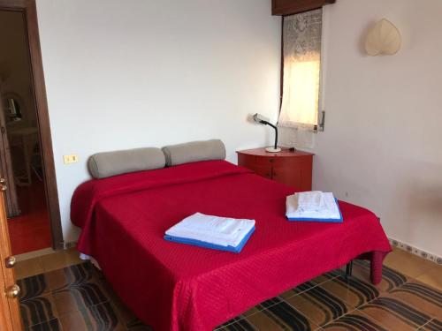 陶尔米纳Villa Mariedda的一间卧室配有红色的床和2条毛巾