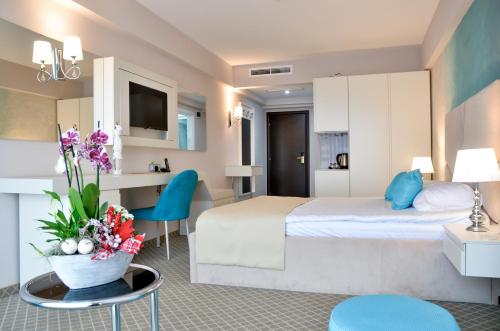 沃莱尼德蒙泰Hotel Afrodita -Valenii De Munte的配有床和鲜花桌的酒店客房
