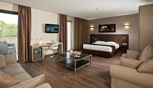 勒卡斯特雷特格兰德普利克斯餐厅酒店的酒店客房设有床和客厅。