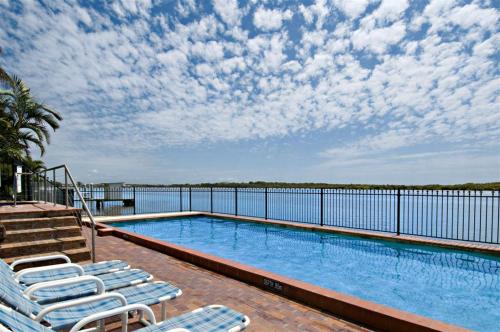 玛志洛榕树塔酒店的一个带躺椅的游泳池,享有水景