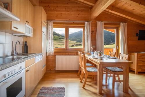 大格洛克纳山麓卡尔斯Haus Panoramablick的厨房配有桌椅和大窗户