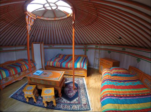 法韦热Yourtes Olachat proche Annecy的圆顶帐篷内带两张床和一张桌子的房间